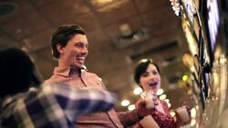 Young guy wins big at casino slot machine, kisses young woman and celebrates with friends Stock Footage