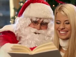 Santa Claus and a young girl reading book Stock Footage