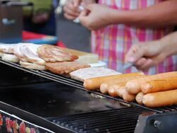 Man grilling pork and sausages . Stock Footage