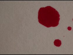 Red dye dropping on a white surface Stock Footage
