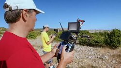 Two men holding controllers and lifting drone into air Stock Footage