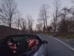 Two beautiful women in a convertible car holding American flag Stock Footage