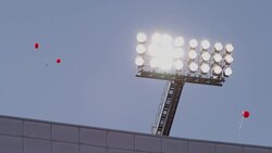 Closeup of collegiate football stadium lights as balloons float to the sky. Stock Footage