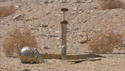 Tumbleweeds surround a soldier's helmet and sword in the ancient emerald mining town of Sikait, Egypt. Stock Footage