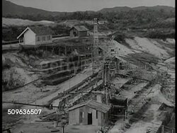 1940 EAST INDIES MINING: CU Photo labeled 'Banka_Tinwinning' HA WS Stepped tin mine. VS Indonesian people washing ore, standing in murky water steps, crane scoop going into wet earth, male working turning mixer. Instructional Video
