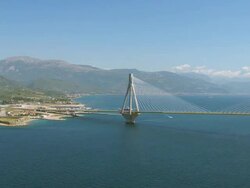 WS AERIAL View of Rio-Antirrio bridge with small town and mountains so far / Rio, Peloponnese, Greece Stock Footage