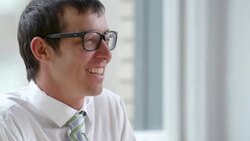 CU Smiling businessman in discussion with coworkers in office Stock Footage