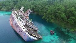 Tourist zodiac passing World Discoverer shipwreck Stock Footage