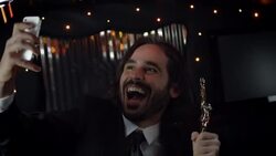 Celebrity with awards trophy snaps selfies with smartphone in back of limousine at awards show Stock Footage