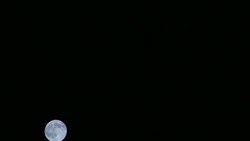 A full moon rises in the winter sky over Saarbruecken, Germany. Stock Footage