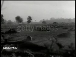 1950: YUGOSLAVIAN ARMY: VS Tank down hill, explosions, Yugoslavian soldiers crawling & charging, in trenches. MS Dictator Josip Tito watching w/ binoculars. VS Tank & infantry moving forward. LA MS Tito wiping head. Instructional Video