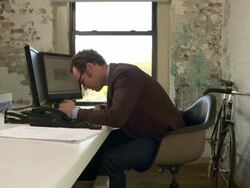 Medium full shot. Camera pushes in on profile of man at desk. He faces screen left. He is disappointed with what he sees on the computer screen and consequently bangs his head on the desk. Stock Footage