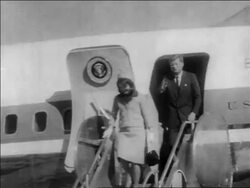 B/W 1963 John + Jacqueline Kennedy exiting Air Force One + descending stairs / Dallas Stock Footage