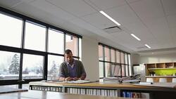 Architect reviewing blueprints and swatch at table in office library Stock Footage