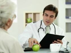 Doctor taking pillsand giving a apple to patient. Stock Footage