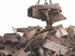 Medium Close Up steadicam tilt-down tilt-up - Heavy machinery works magnetically to move a pile of scrap metal / Claymont, Delaware  Stock Footage