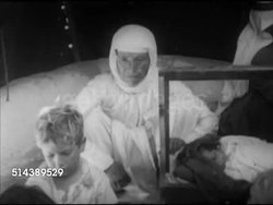 1952: ARAB-ISRAELI WAR REFUGEES: VS Palestinian Arabs in tent city, mother cooking w/ family, children, grandmother rocking cradle, CU Grandmother, MS Sleeping baby. VS Men sitting outside tents, man reading communist paper SOT (Arabic/English). Instructional Video