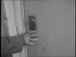 A gloved hand turns a doorknob and opens a door. News Clip