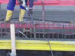 Worker Directing Concrete Onto The Construction Site CU Stock Footage