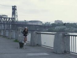 MS SLO MO Shot of young female jogger stands at water front railing and looks over east city / Portland, Oregon, United States  Stock Footage