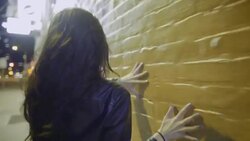 Young woman runs her hand along wall mural in downtown Austin, Texas at night Stock Footage