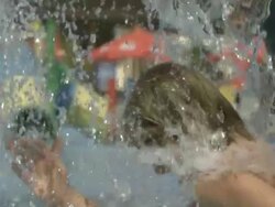 High Speed Boy runs through water shower, close up. (Individual frames may also be used as a still image. Each frame in its raw state is about 6MB or about 12MB as a 16 bit TIFF) Stock Footage