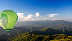 Green hot air balloon over the hill Stock Footage