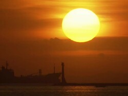 Long Shot Locked Down - Silhouette of a tanker ship with the huge yellow disk of the setting sun / Manilla philippines Stock Footage