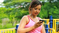 Young woman listening music in playground Stock Footage