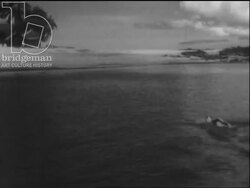 Madagascar c.1958 - Tourists relax on sailboats and on the beach. Woman in a bikini sunbathes. Stock Footage