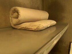 Low Angle hand-held push-out - A rolled-up pillow lies on the top bunk in an empty prison cell. / California, USA Stock Footage