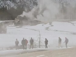 MS Tourists walking past geysers in snow / Yellowstone National Park, Wyoming, United  Stock Footage