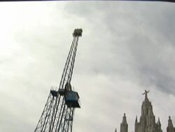 Wide Shot_tilt-down - Carnival patrons stroll past a large carnival ride. / Barcelona, Spain Stock Footage