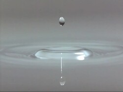 Water droplet falling into water, high speed Stock Footage