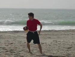 A group of guys playing flag football on the beach. Stock Footage
