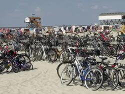 WS Shot of parked bicycle and people relaxing on roofed wicker beach chair at beach near cafe, North Sea North Frisia, / St. Peter Ording, Schleswig Holstein, Germany Stock Footage