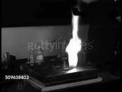 1941: FBI TRAINING AT QUANTICO: Professor in classroom setting lighting flammable material, demonstration of incendiary bomb fuse. FBI Agents taking notes in class. Instructional Video