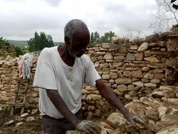 Ethiopian men build a stone enclosure Stock Footage