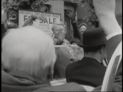 Prime Minister Winston Churchill gives the victory sign while riding in a convertible through a crowd. News Clip