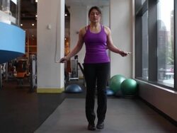 Wide shot of woman working out at the gym, jumping rope. Stock Footage