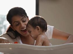 Woman washing her baby in a bathtub Stock Footage