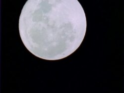 T/L full Moon rising, dark clouds pass from left to right, black background, CU, Panama. Stock Footage