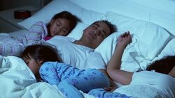 Family in bed together sleeping Stock Footage