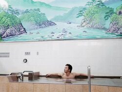 WS A man splashes water over his face in a traditional Japanese public bath house or sento / Tokyo, Japan Stock Footage