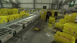Staff working in a busy Amazon warehouse on Black Friday News Clip