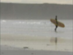 Surfers on UK beach. 2006; short sequence. Stock Footage