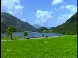 WA paraglider flying over Lake Halden, Tyrol, Austria Stock Footage