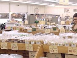 WS PAN fruit orchard store selling dried fruit and nuts in plastic bags as shoppers browse aisles / Cabazon, California, USA Stock Footage