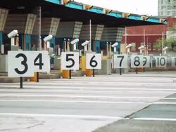 Time lapse, medium shot, toll booth exits, multiple cars and traffic drive away down the interstate highway. Stock Footage