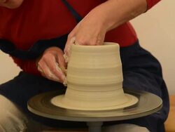 MS Shot of female potter shapes pot from lump of clay on potters wheel at pottery / Landshut, Bavaria, Germany Stock Footage